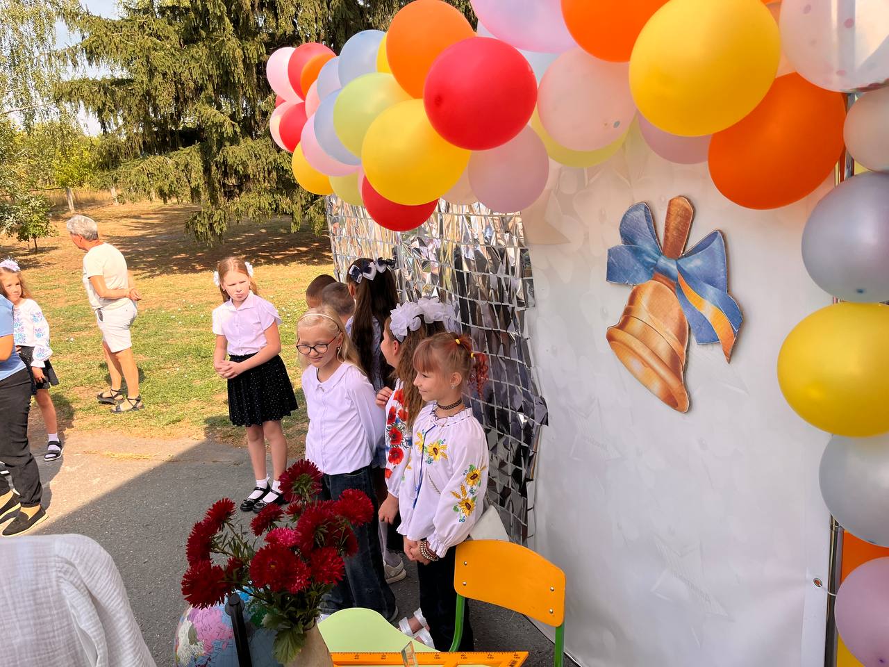 Першокласники біля святкової фотозони з повітряними кульками